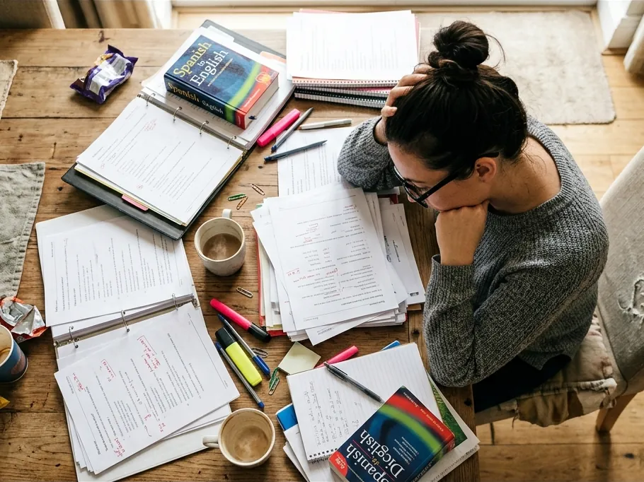 Teacher reviewing lesson materials and student work at a desk